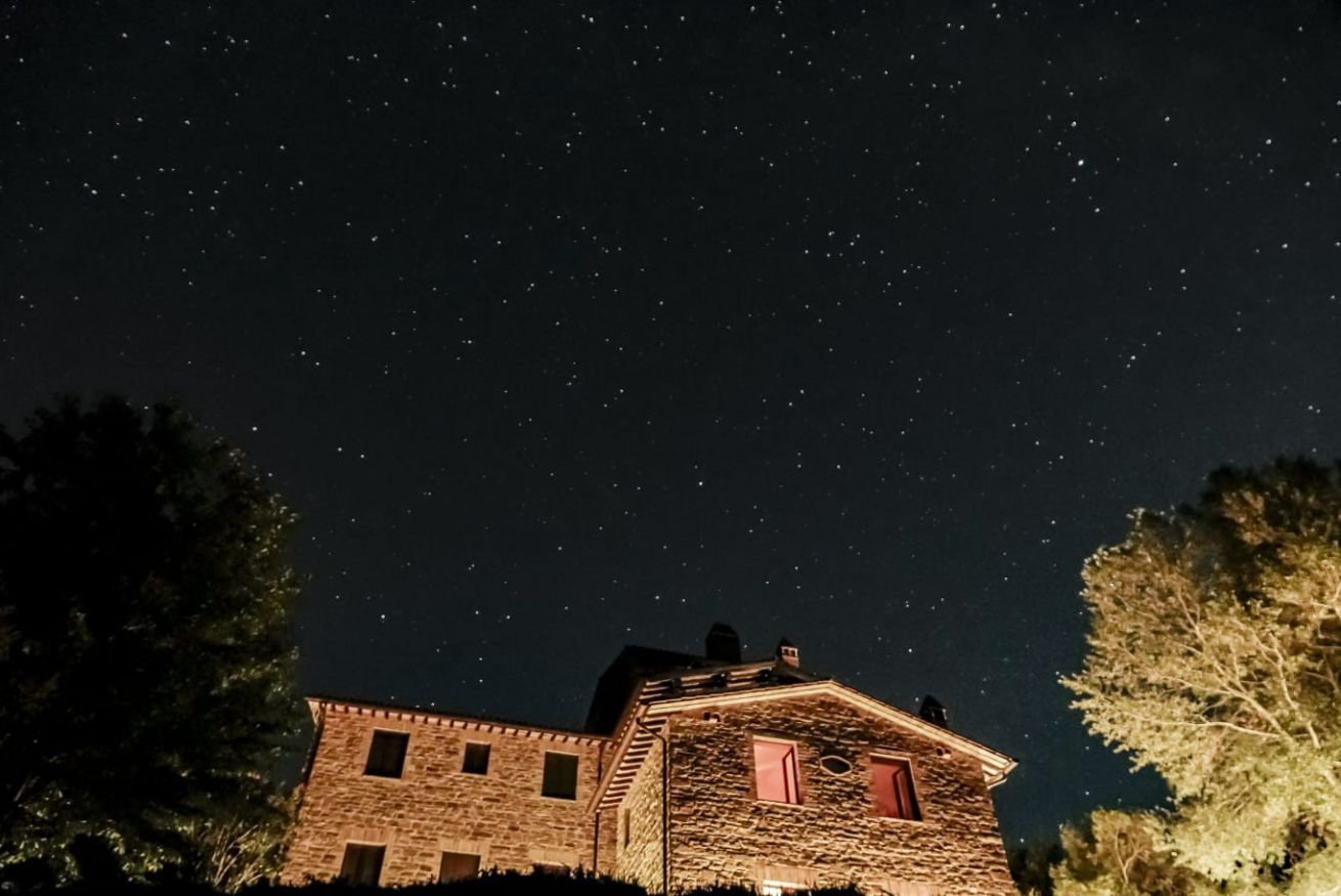 Um edifício de pedra com várias janelas e um céu noturno estrelado.