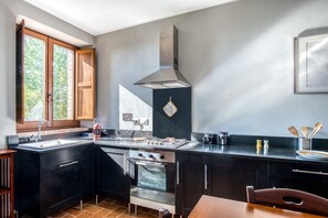 A modern kitchen with a stove, oven, and a large window.