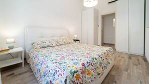 A bedroom with a bed, bedside tables, a lamp, and a wardrobe. - GuestHost - Borgata Santa Lucia Cozy Apartment! (Siracusa)