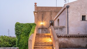 Un escalier menant à un bâtiment doté d’un mur en pierre et d’un toit en métal.