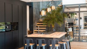 Une cuisine moderne dotée d’un îlot central, de tabourets de bar et d’un meuble à vin.