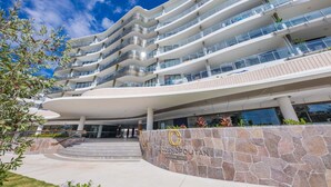 Ein mehrstöckiges Hotel mit moderner Architektur, mit Balkonen und einer Stein-Fassade.