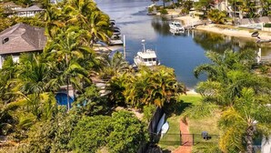 A swimming pool surrounded by lush greenery and a marina with boats. - Lovely 2 bedroom ground floor apartment in Noosa Heads with generous private courtyard. (Noosa Heads)