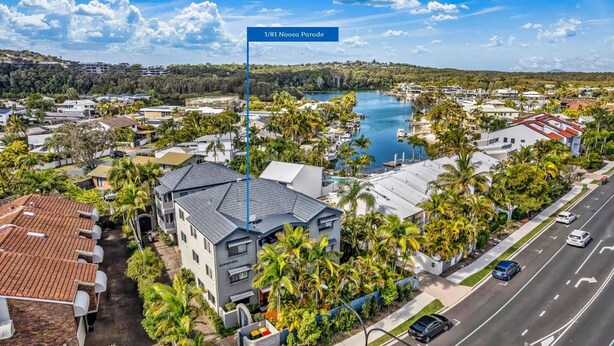 An aerial view of a residential area with a marina, houses with red-tiled roofs, and palm trees. - Lovely 2 bedroom ground floor apartment in Noosa Heads with generous private courtyard. (Noosa Heads)