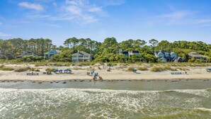 A beachfront property with multiple houses, a sandy beach, and a river.