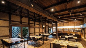 A rustic interior with wooden beams, tables with menus, and a bar area. - NIPPONIA HARIMA FUKUSAKI ZOUSHONO YAKATA (Fukusaki)