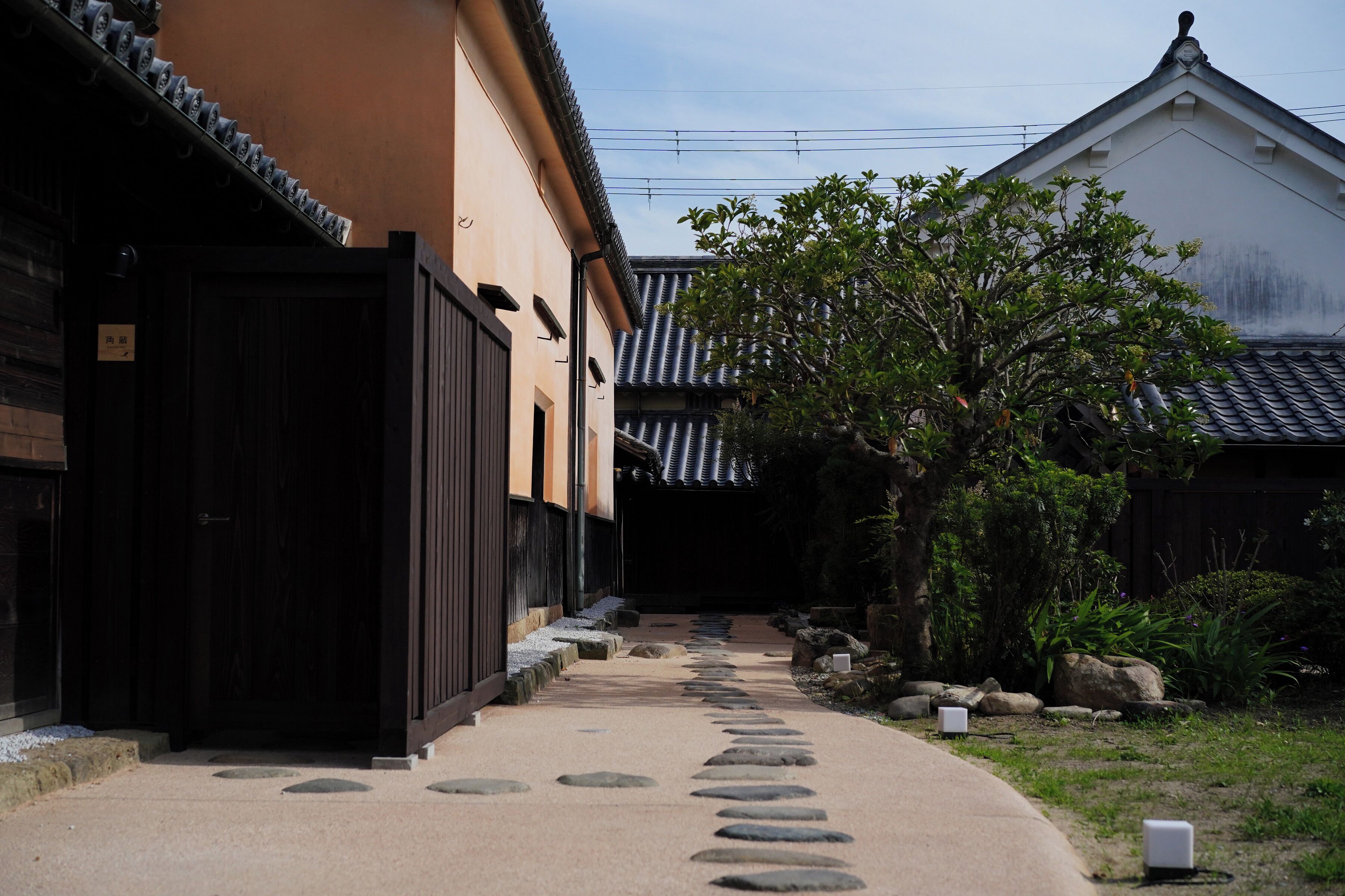 En traditionel japansk bygning med en stentrappe, der fører til en træport.