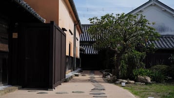 En traditionel japansk bygning med en stentrappe, der fører til en træport.