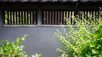 A traditional building facade with a dark wall and a tiled roof.