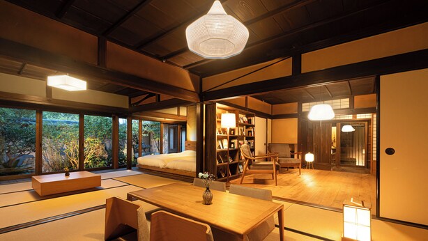 A traditional Japanese-style room with tatami flooring, a low wooden table, and a sofa. - NIPPONIA HARIMA FUKUSAKI ZOUSHONO YAKATA (Fukusaki)