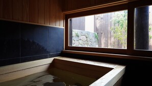 A wooden bathtub with a stone wall and a window. - NIPPONIA HARIMA FUKUSAKI ZOUSHONO YAKATA (Fukusaki)