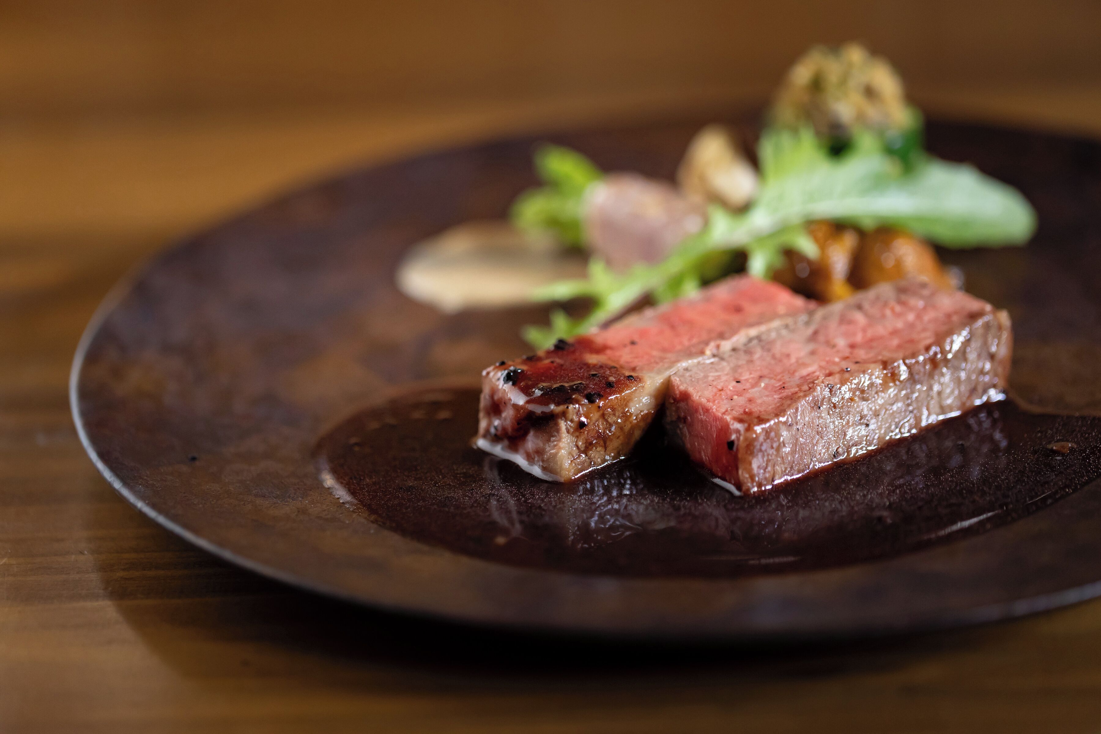 Un bife con salsa oscura en un plato.