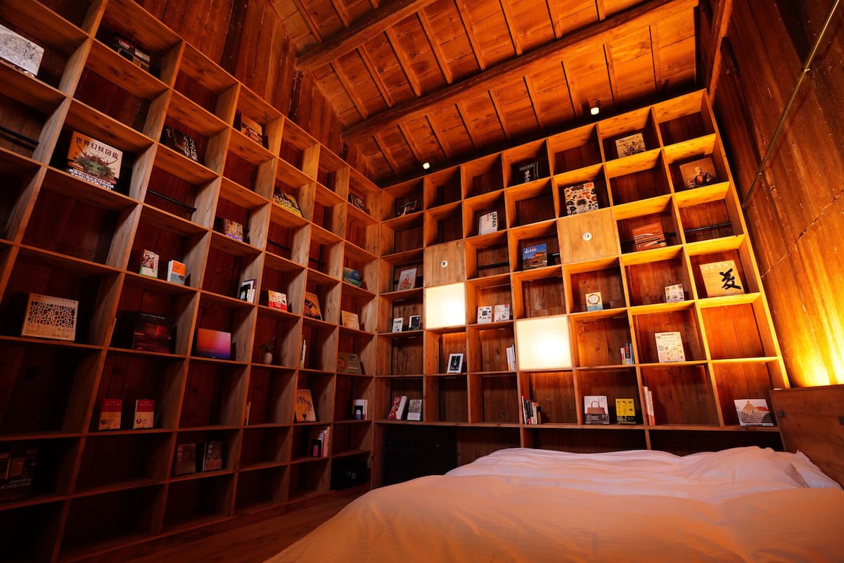 Ein Zimmer mit einem großen, hölzernen Bücherregal, gefüllt mit Büchern und dekorativen Gegenständen.