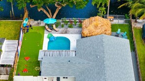 Ett tvåvåningshus med en swimmingpool, en inhägnad trädgård och en liten terrass.