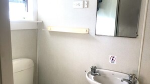 A small bathroom with a toilet, a sink, and a mirror.