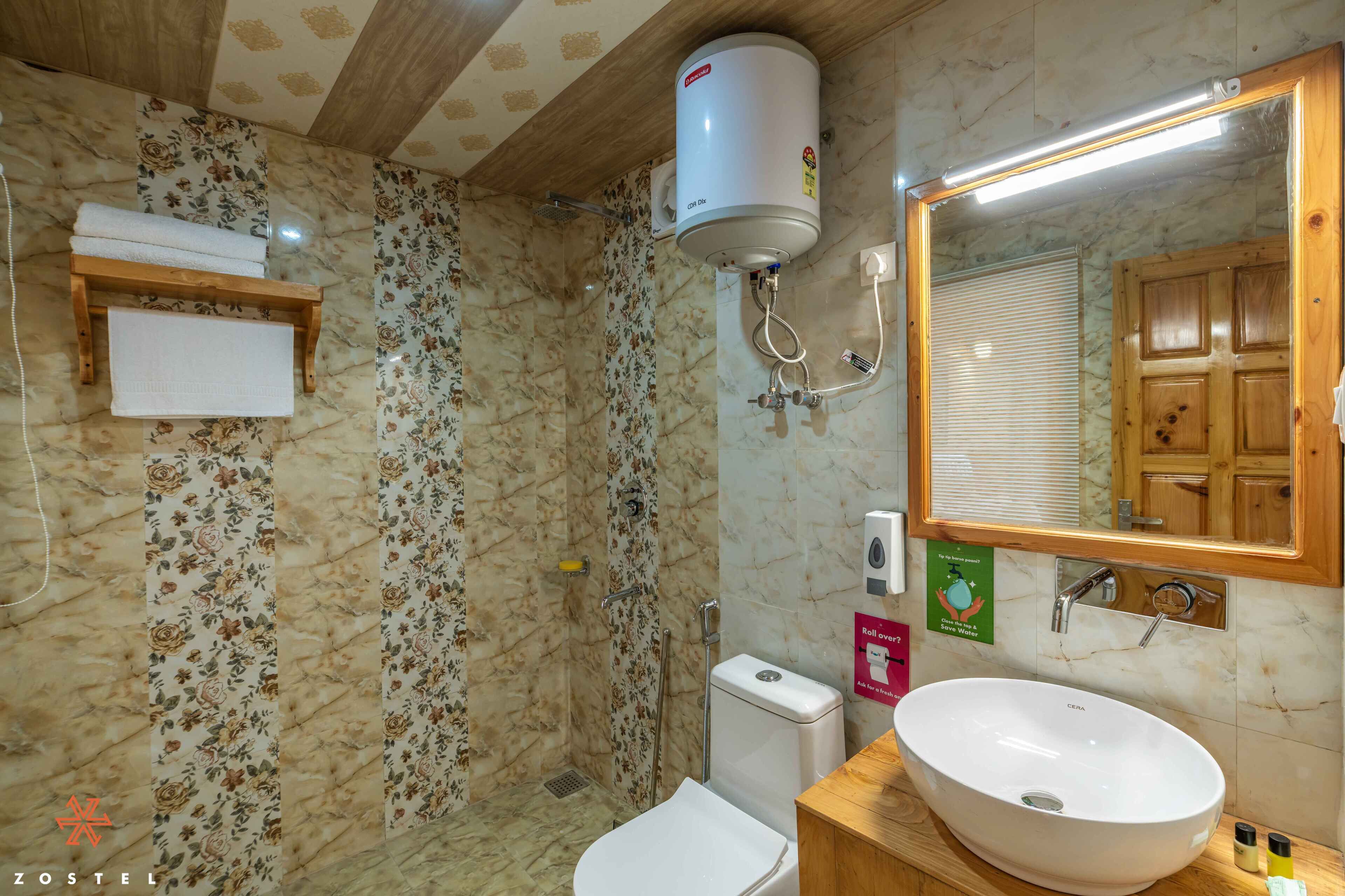 Un baño con pared de ducha de mármol, inodoro, lavabo y espejo.