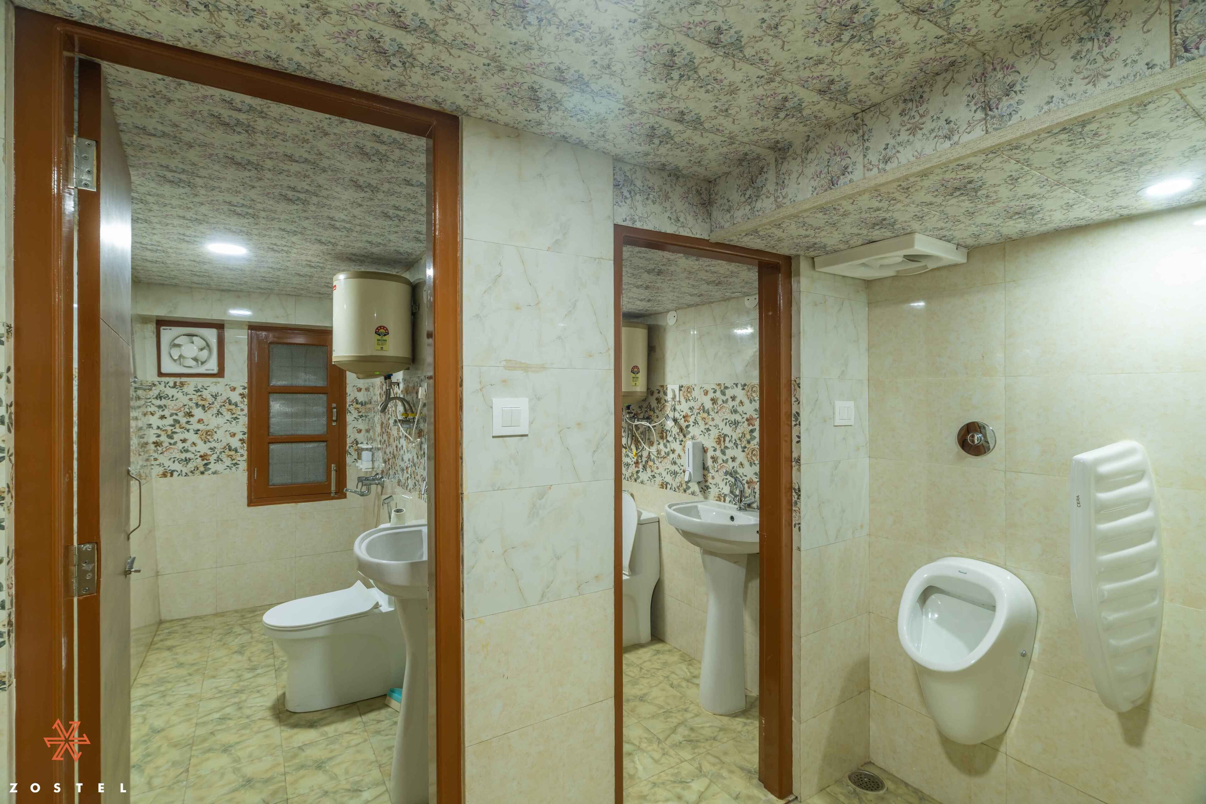 Een badkamer met toilet, wastafel, urinoir en spiegel.