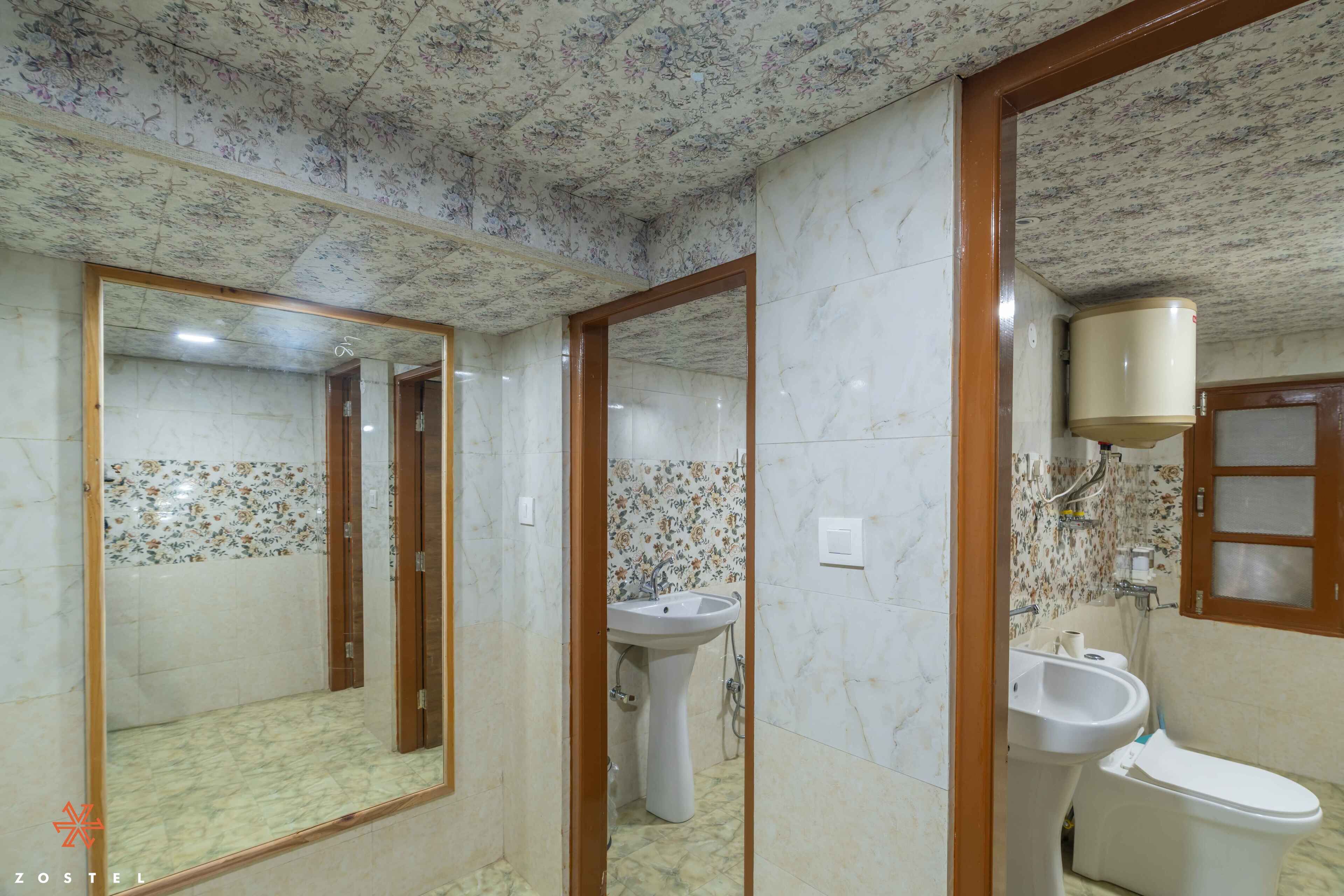 A bathroom with a large mirror, a sink, and a toilet.