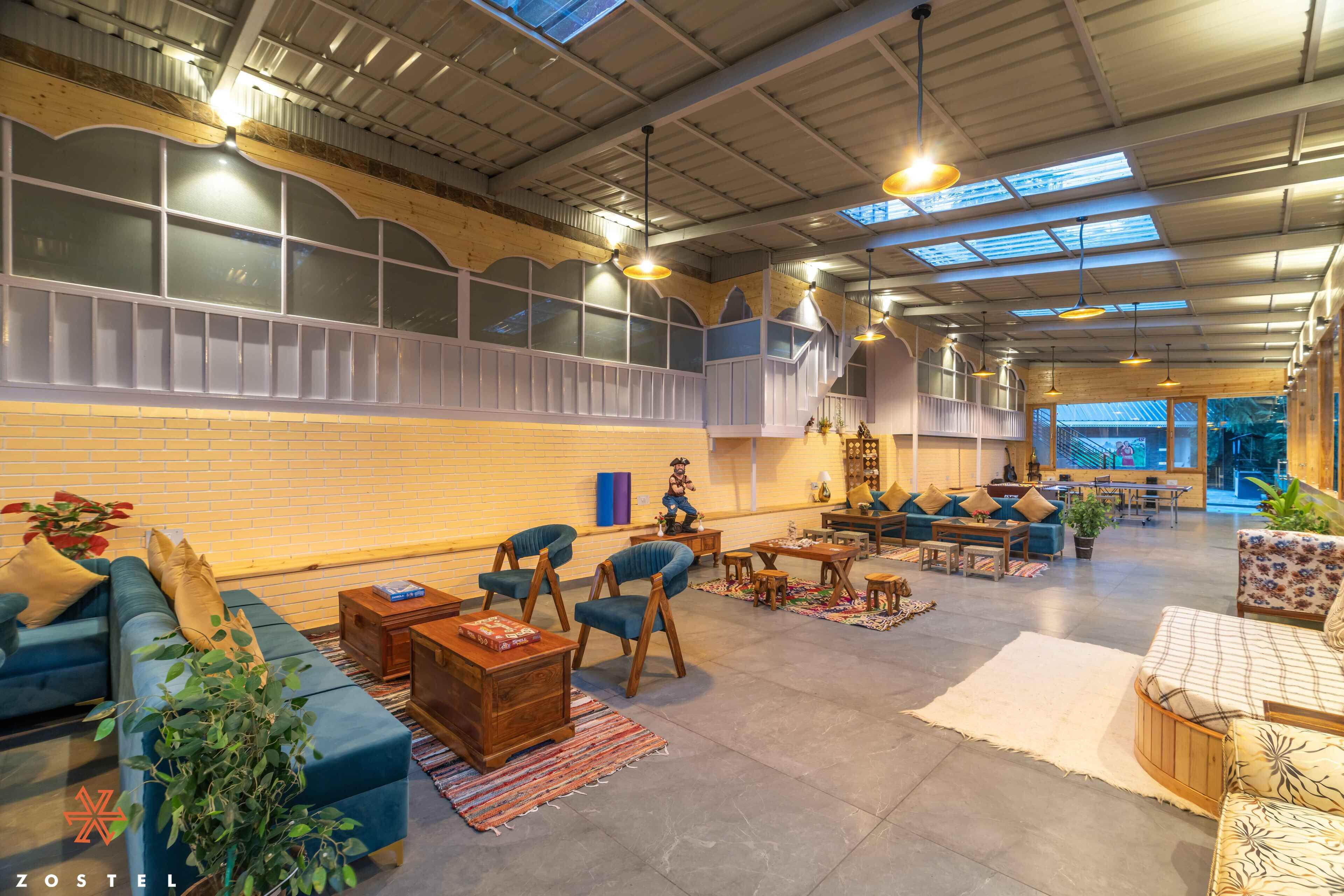 A spacious lounge area with a high ceiling, large windows, and a variety of seating options including sofas and chairs.