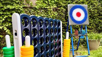 Zona de juegos infantiles con un objetivo de tiro con pelota y una estructura para escalar.