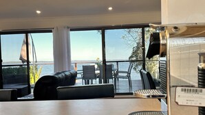 Une pièce avec vue sur la mer, une table, des chaises et un canapé.