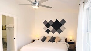 A bedroom with a bed, a ceiling fan, a wall-mounted artwork, bedside lamps, and a bench. - Alpine Townhouse - stylish, peaceful, and walking distance to Ellicottville (Ellicottville)