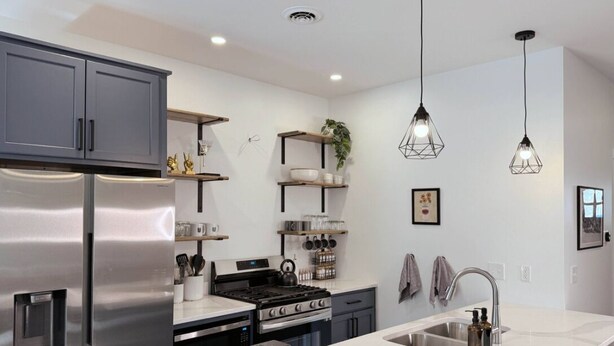 A modern kitchen with stainless steel appliances, a central island with a sink, and pendant lighting. - Alpine Townhouse - stylish, peaceful, and walking distance to Ellicottville (Ellicottville)