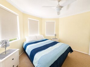A bedroom with a bed, a nightstand, a lamp, and a ceiling fan. - Meelup Ridge (Dunsborough)