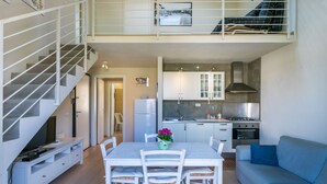 Eine moderne Wohnung mit Essbereich, Küche und einer Treppe zu einer oberen Ebene.