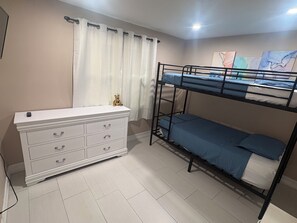 A bunk bed with a dresser and a curtain. - Charming 3-bedroom house with pool, AC, WiFi in pleasant Tampa (Tampa)