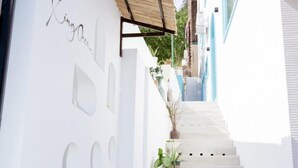A white building with a staircase leading to a blue door. - Xing Ocean Homestay VT by Bay Luxury (Ho Chi Minh City)
