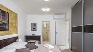 A hotel room with a bed, bedside table, desk, shower, and wardrobe. - 3BR Istrian Villa Erla w/ Private Pool, Labin, Croatia (Labin)