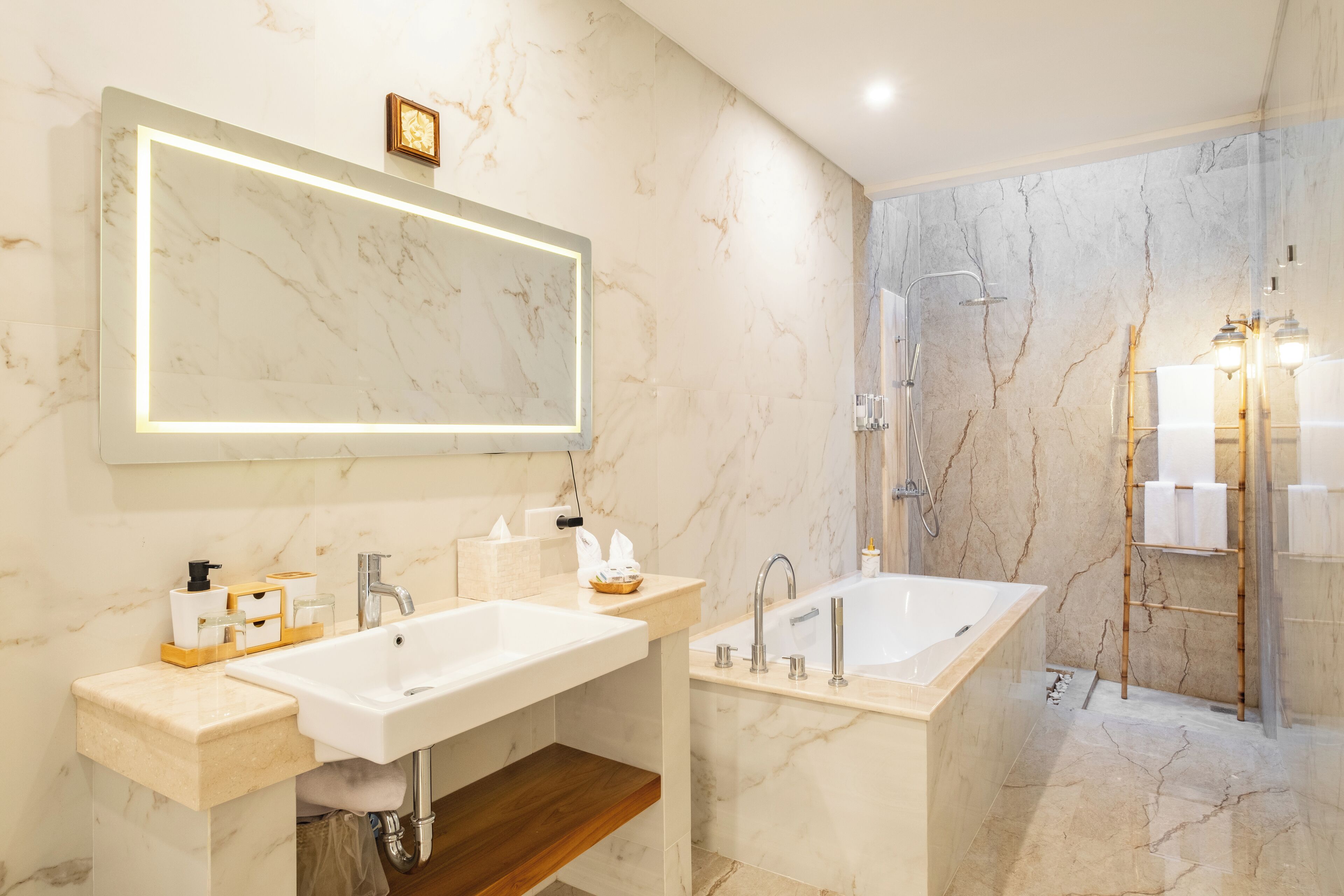 Un baño moderno con un espejo grande, un lavabo, una bañera y una ducha.