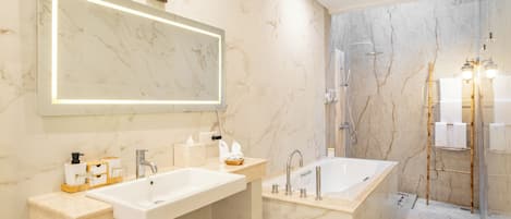 Un baño moderno con un espejo grande, un lavabo, una bañera y una ducha.