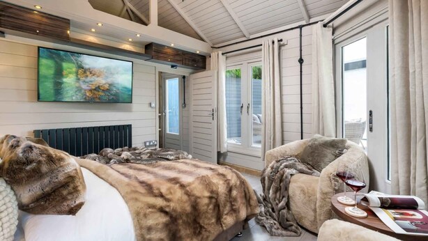Ein Schlafzimmer mit einem großen Bett, einem Sofa, einem Weinglas und einem Bild an der Wand.