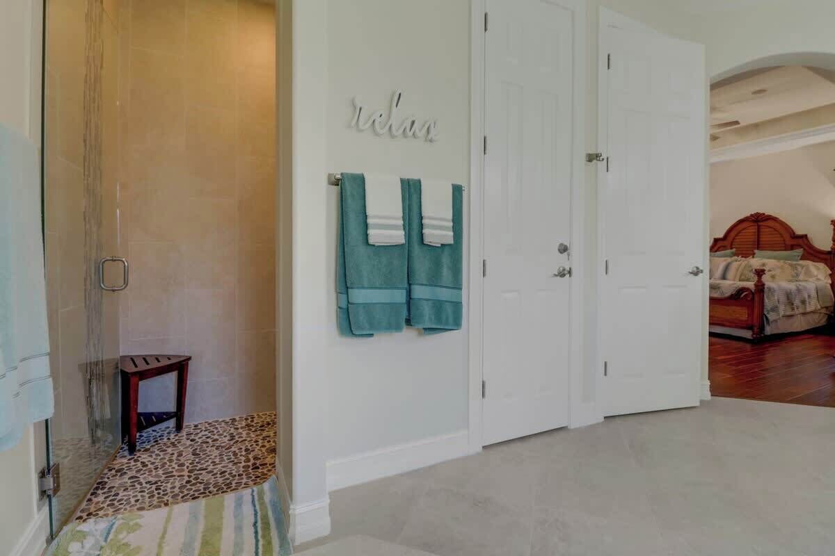 A bedroom with a wooden bed, a white door, and a wall-mounted towel rack with two towels.