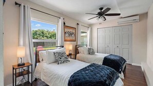A bedroom with two beds, a ceiling fan, and a window with curtains. - 3BR Retreat in St. Pete - Close to beaches (St Petersburg)