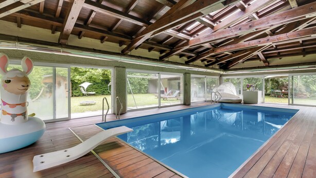Ein Hallenbad mit Holzbalken, einer Rutsche und einer großen aufblasbaren Hasen-Dekoration.