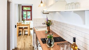 Eine moderne Küche mit Holzarbeitsplatten, einem eingebauten Backofen und Pendelleuchten.