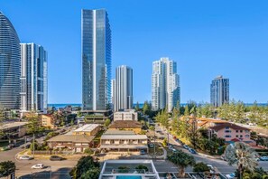 A coastal cityscape with high-rise buildings, a clear blue sky, and a mix of residential and commercial structures. - Broadbeach Ocean View Apartment - Wifi & Parking (Broadbeach)