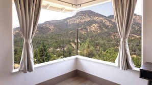 A corner room with a large window overlooking a mountainous landscape. - Shasta Lake Beautiful House w/ Hot Tub, BBQ, Ping Pong & Foosball Table (Redding)
