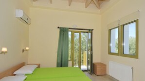 A room with a bed, a window, a radiator, and a sliding door to a balcony. - Villa Pinelopi With 2 Bedrooms and 3 Bathrooms (Kefalonia)