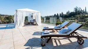 A rooftop terrace with two sun loungers, a canopy, and a seating area with a table and chairs. - Villa Noulia With 4 Bedrooms and 2 Bathrooms (Corfu)
