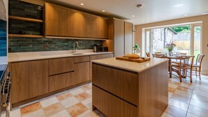 A modern kitchen with wooden cabinets, a tiled backsplash, and a central island.