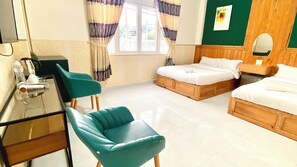 A hotel room with a bed, two chairs, a desk, and a window with curtains. - Ruby Peace Hotel (Xuan Huong - Da Lat)