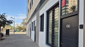 A modern building with a black door marked '06', large windows, and a clean, paved walkway. - 💫romantic Apartment by Virkin Suites 4💫a 7 Minutos Andando del Oceanográfico! (València)