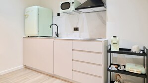 A compact kitchen with a sink, a microwave, and a stove hood. There are cabinets with drawers and a shelf with kitchen items. - 💫romantic Apartment by Virkin Suites 4💫a 7 Minutos Andando del Oceanográfico! (València)