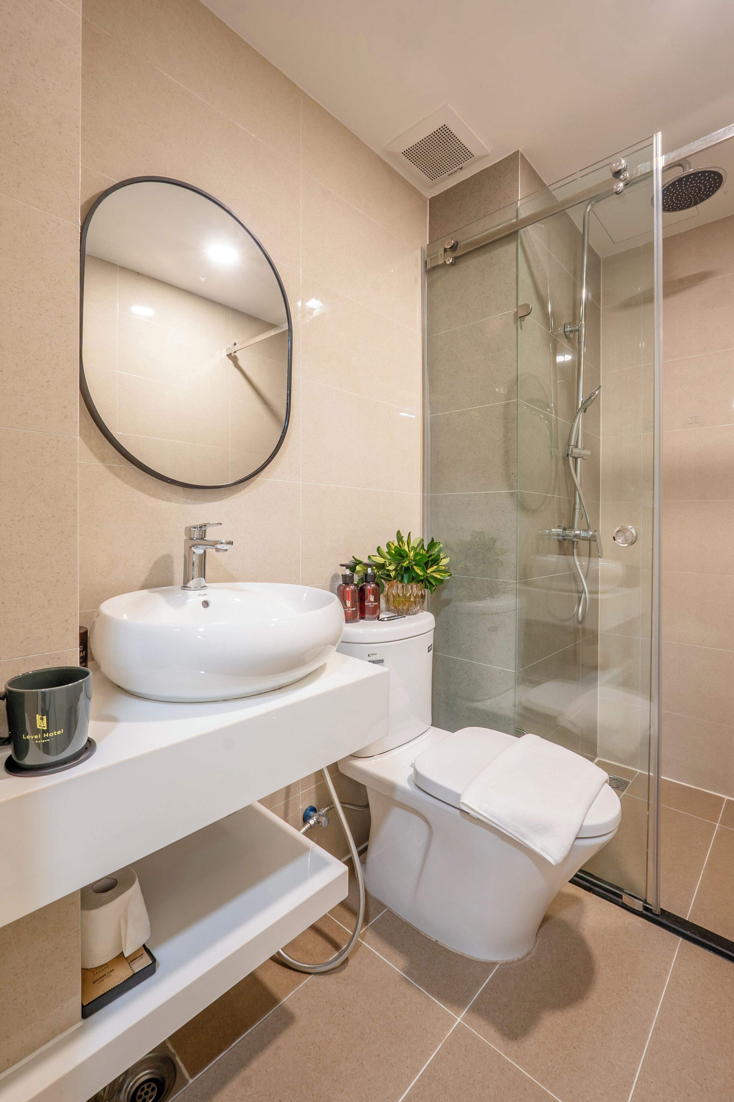 Une salle de bain moderne avec un lavabo blanc, un miroir et une douche à parois de verre.
