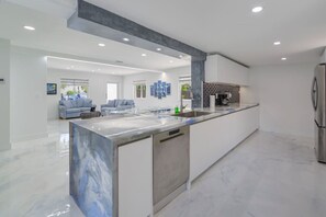 Una cucina moderna con un piano di lavoro in marmo, elettrodomestici in acciaio inossidabile e una grande isola.