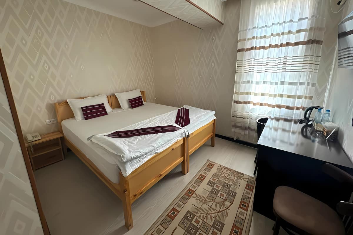 Una camera da letto con un letto, un comodino, una sedia e una scrivania con altra sedia.